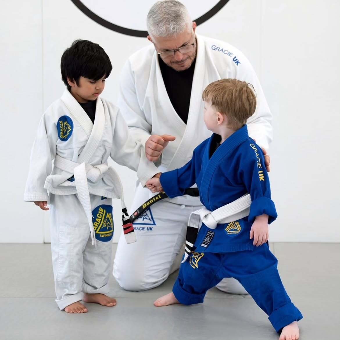 Instructor tying a young student's belt at Gracie Swindon