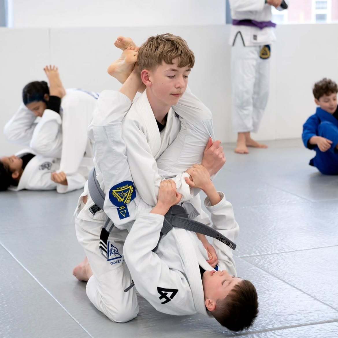 Older kids practising Jiu-Jitsu technique