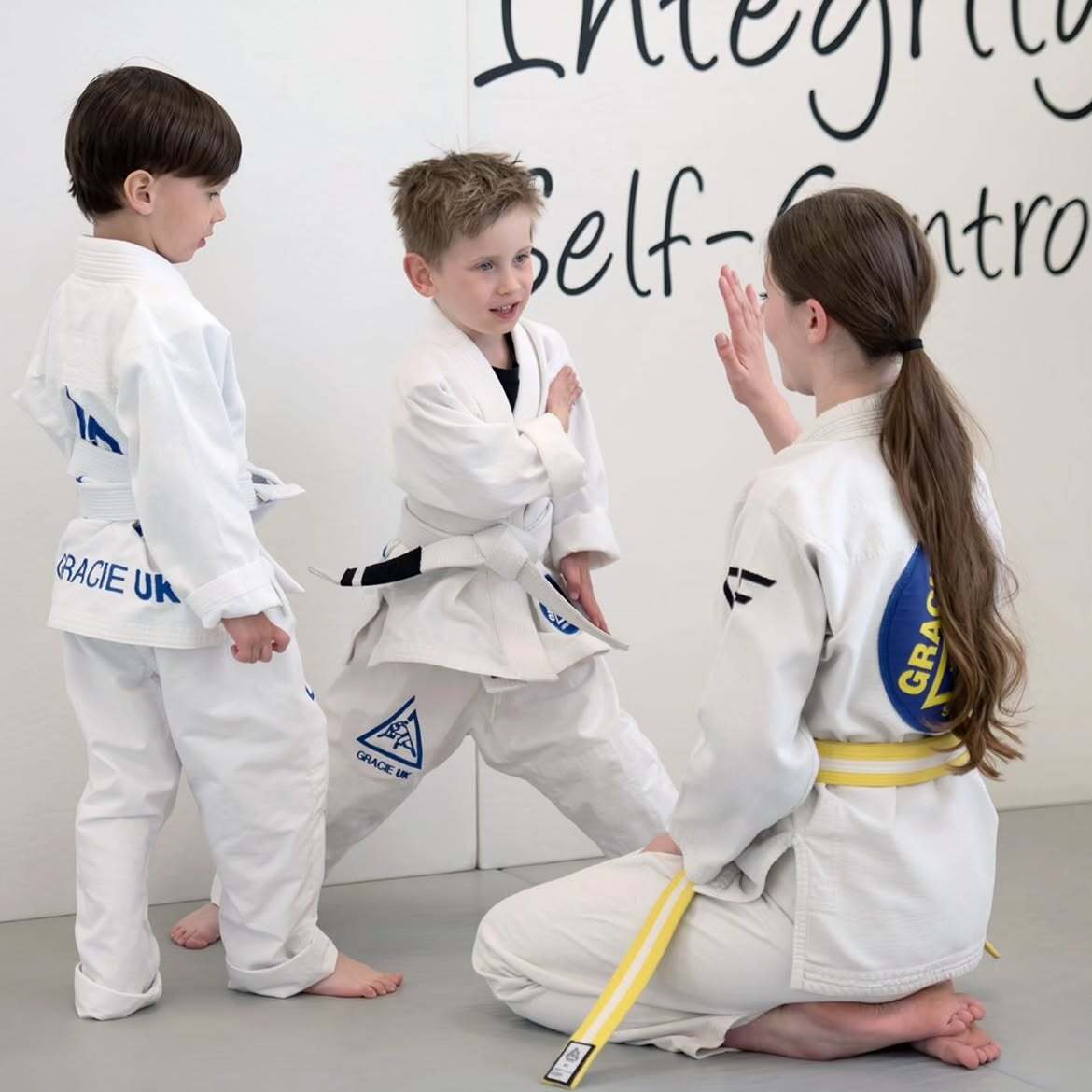 Kids practising discipline in front of the academy's core values wall